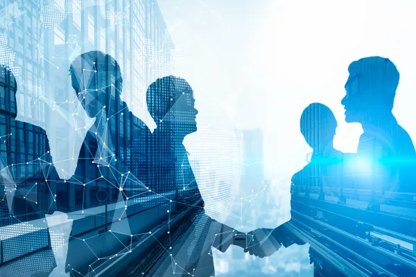 Silhouetten von Geschäftsleuten beim Handschlag mit vernetzter Weltkarte im Hintergrund.