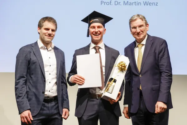 Dr. Christian Frommelt und Prof. Dr. Martin Wenz neben Dr. Kasem Zotkaj mit seinem Diplom.