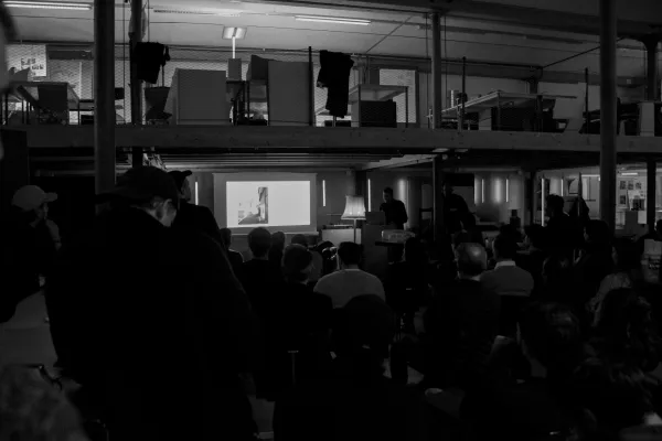 Schwarz/weiss Aufnahme mit Publikum und Vortragendem