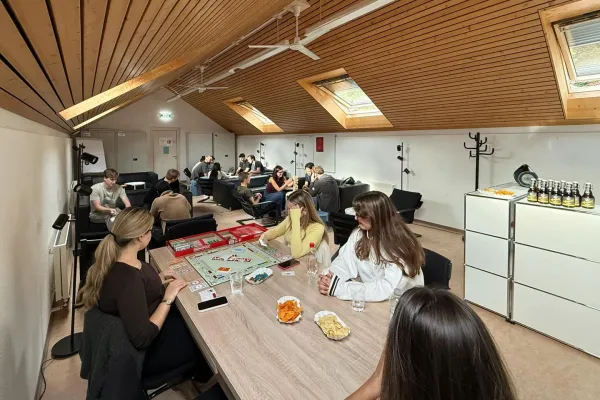 Mehrere Studierende sitzen in einem Raum und spielen