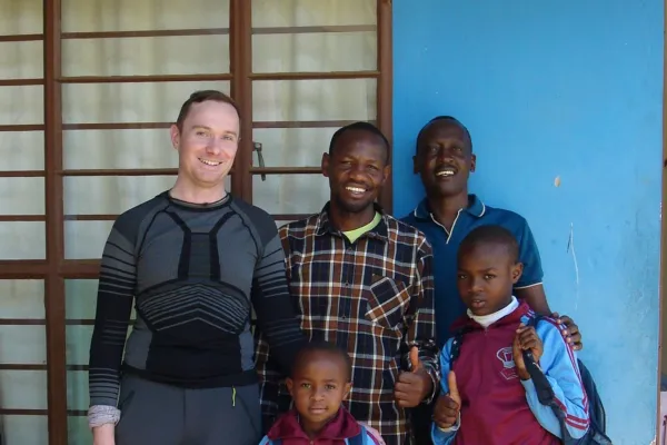 Gruppe von Personen steht vor einem blauen Gebäude.