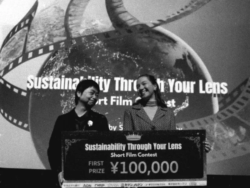 Schwarz-Weiss Aufnahme von zwei Frauen mit einem grossen Scheck in der Hand